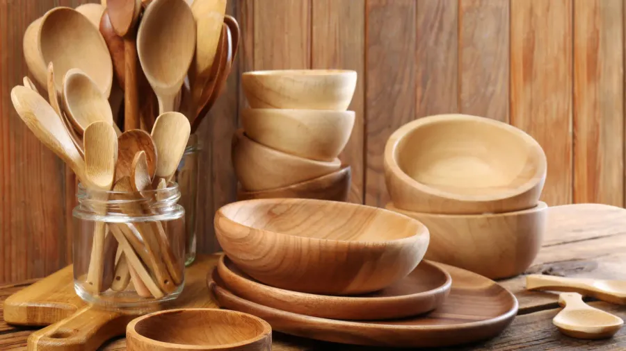 many different wooden dishware and utensils on table
