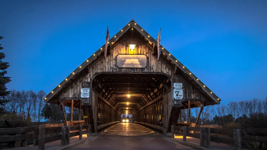 michigan covered bridge car entering historic covered bridge illuminated at