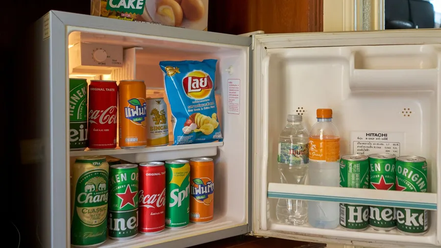A mini fridge stocked with snacks, water, and drinks.