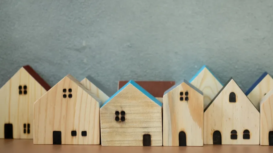 miniature wooden houses building blocks arranged in row selective focus