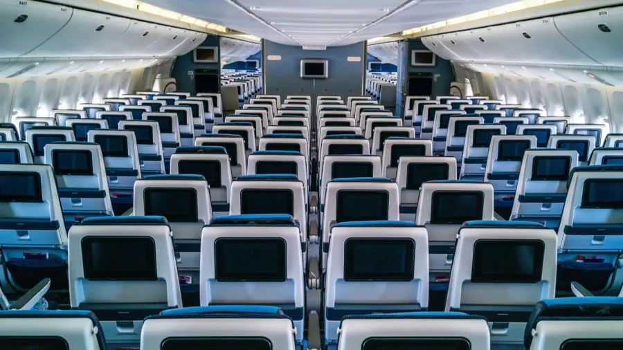modern aircraft interior with seats and blank touch entertainment screens