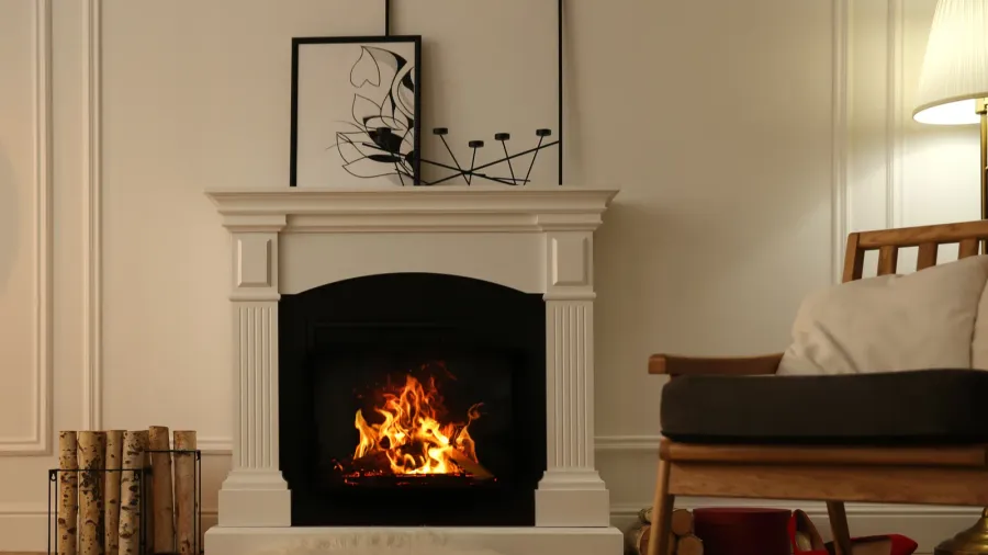 Modern fireplace with burning wood and decor on top of it.