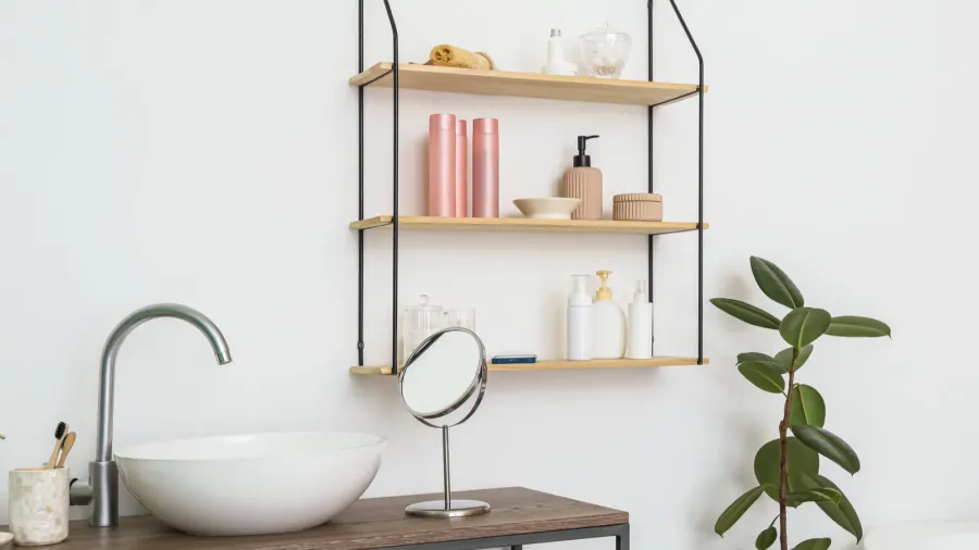 modern sink and bath accessories on table near white wall