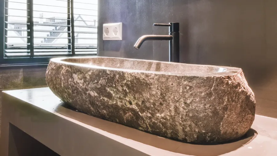 Modern natural stone vessel sink in bathroom.