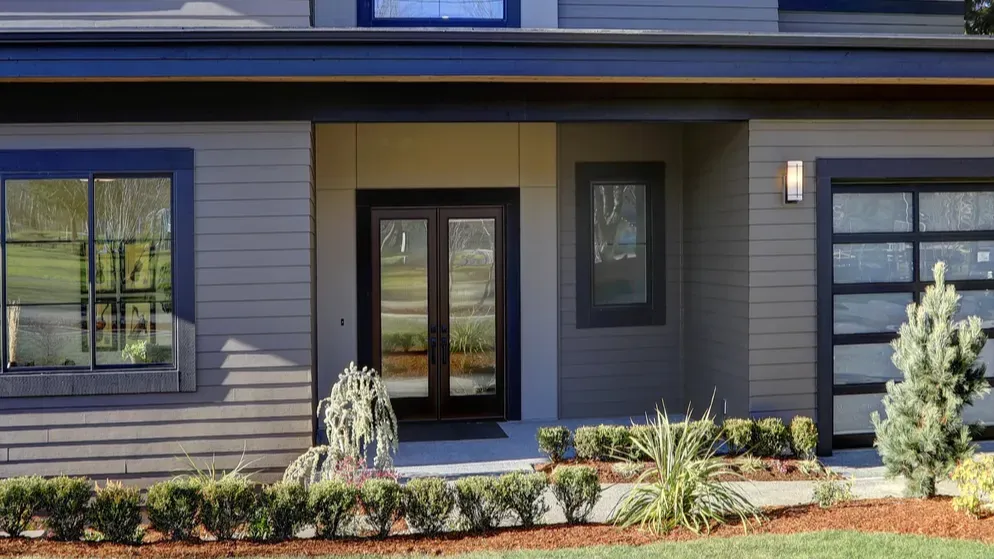 new construction home with low slope roof and brown siding