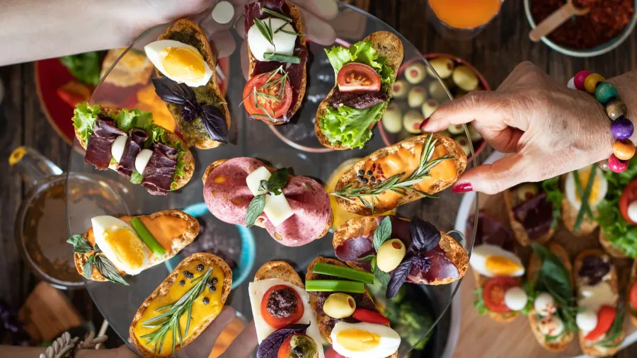 offering and serving many kinds of tapas to people hands
