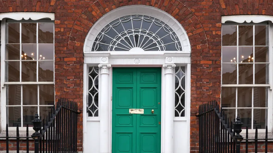 Old georgian brick townhouse with transom window above door.