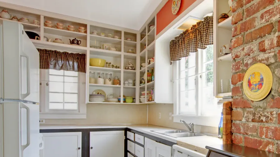 old simple white kitchen with brick wall