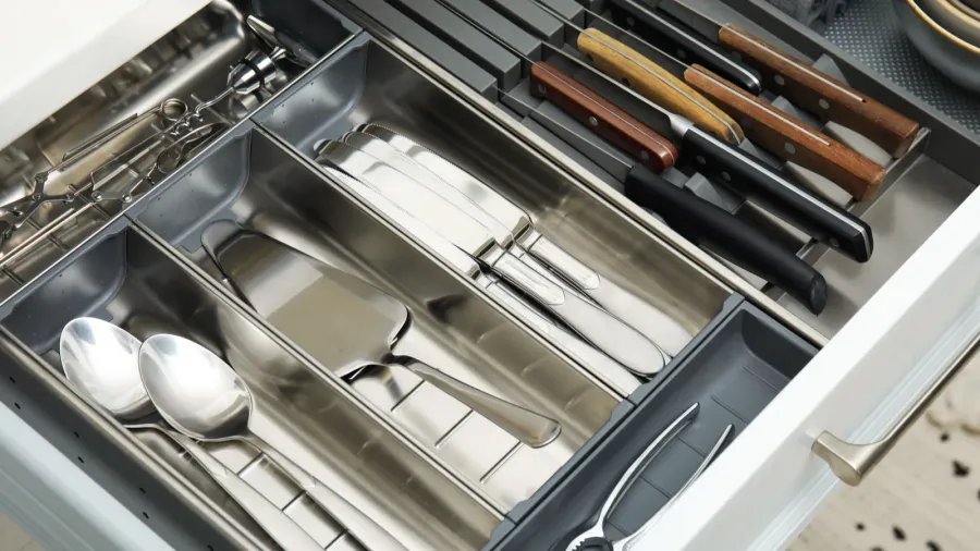 open drawer of kitchen cabinet with different utensils dishware and