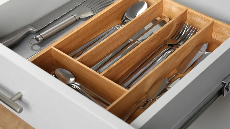 open drawer with different utensils and folded towels order in