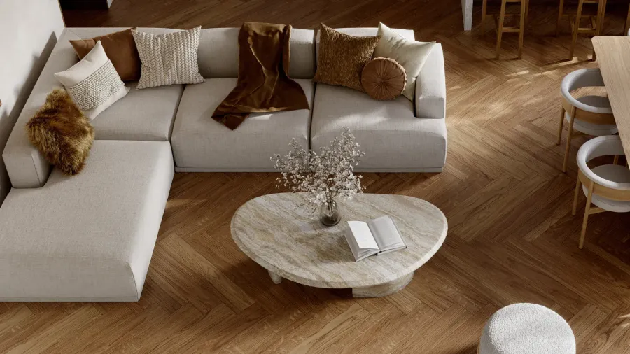 An open plan living room interior with gray modular sofa with throw pillows, marble coffee table, and wooden dining table with chairs.
