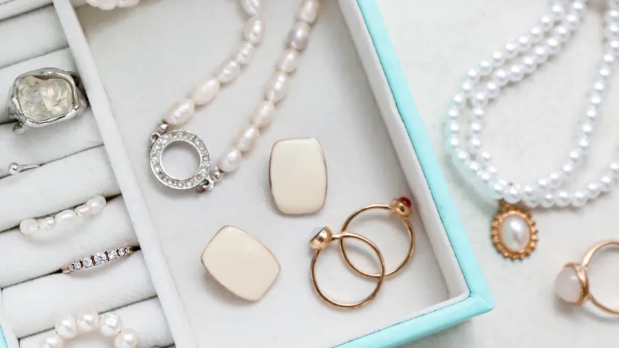 A stylish jewelry organizer with rings, earrings, and necklace in it.