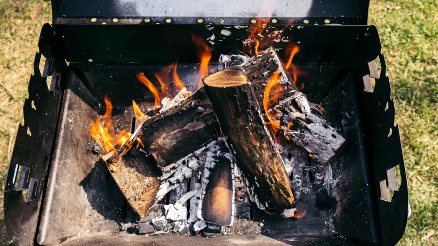 outdoor grill with burning firewood for barbecue