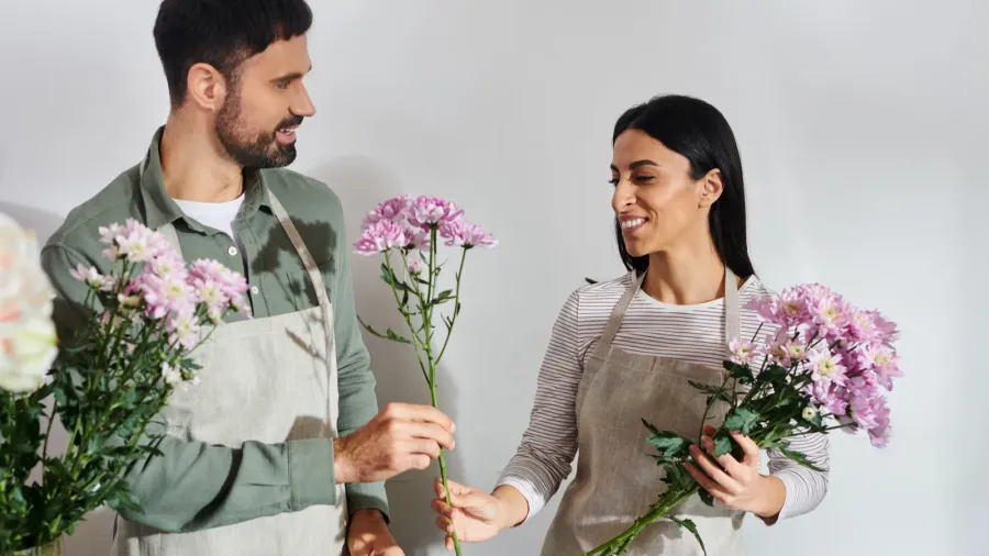 owners of a florist shop joyfully arrange flowers while showcasing