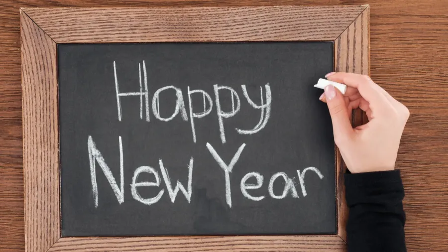 partial view of woman writing happy new year text on