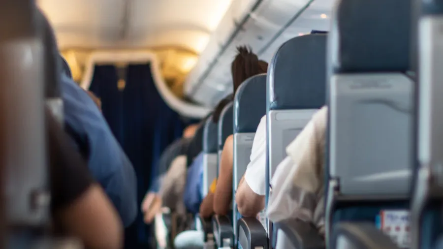 passenger seat interior of airplane with passengers sitting on seats
