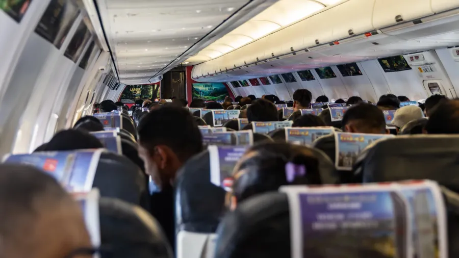 passenger sitting in a civil airliners economy class seat during