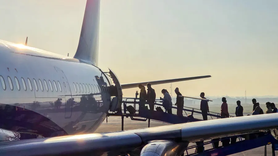 passengers boarding aircraft via a ramp near the tail exit
