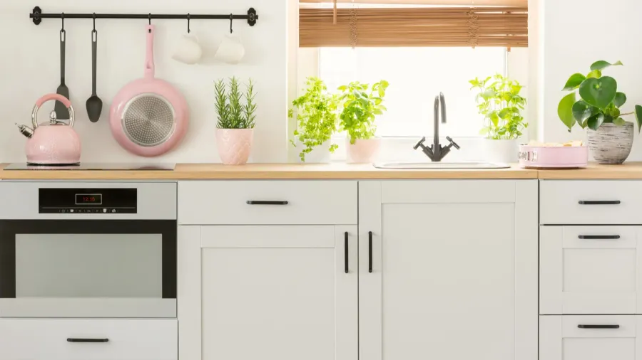 pastel pink pan and kettle in a beautiful kitchen interior