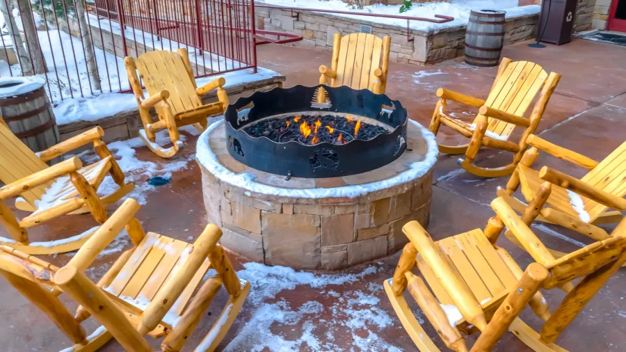 patio with wooden rocking chairs around a fire pit