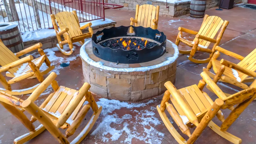 patio with wooden rocking chairs around a fire pit