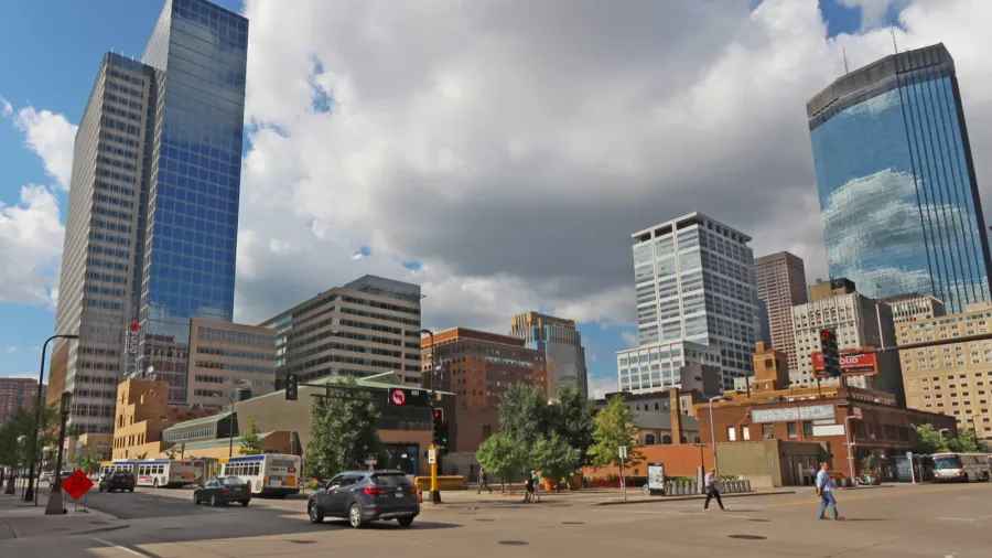 pedestrain and car traffic and a partial skyline of minneapolis