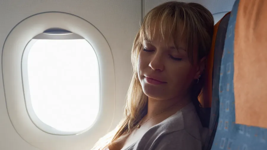 people travelling relaxed woman sleeping on plane