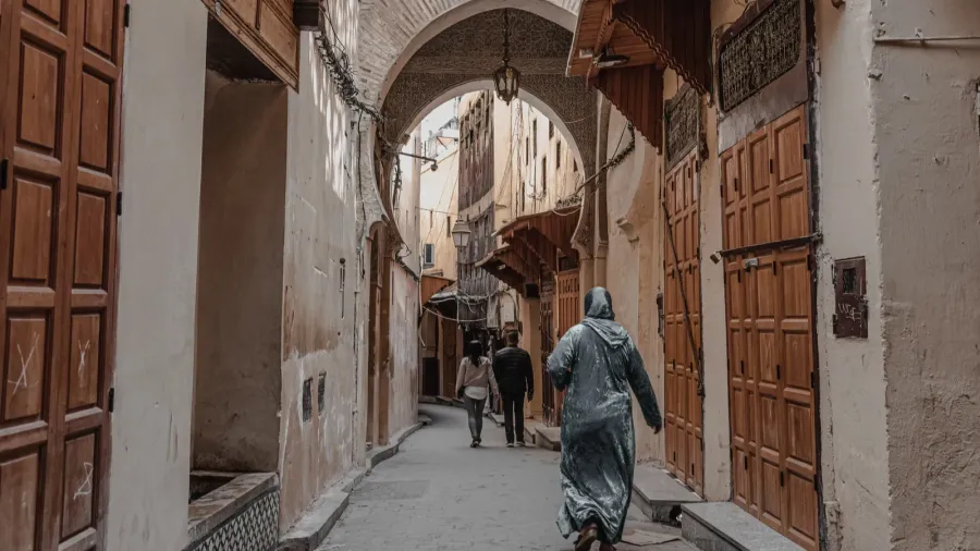 people walking through an empty street in the old medina