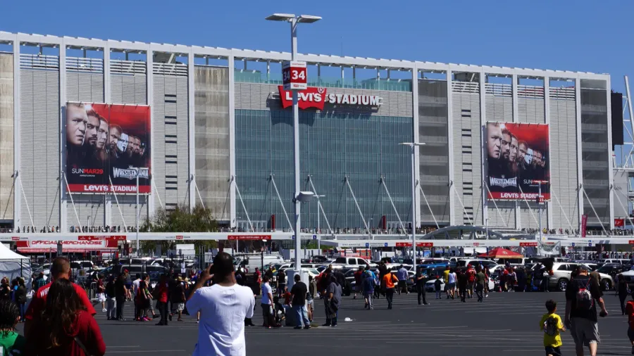 People walking to arena and tailgate in parking lot.
