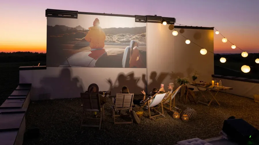 people watching movie on the rooftop terrace at sunset