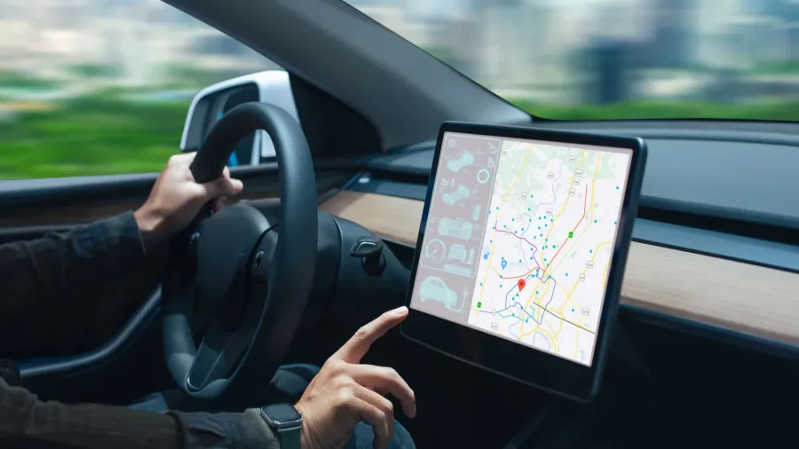 person driving a car while interacting with a modern touchscreen