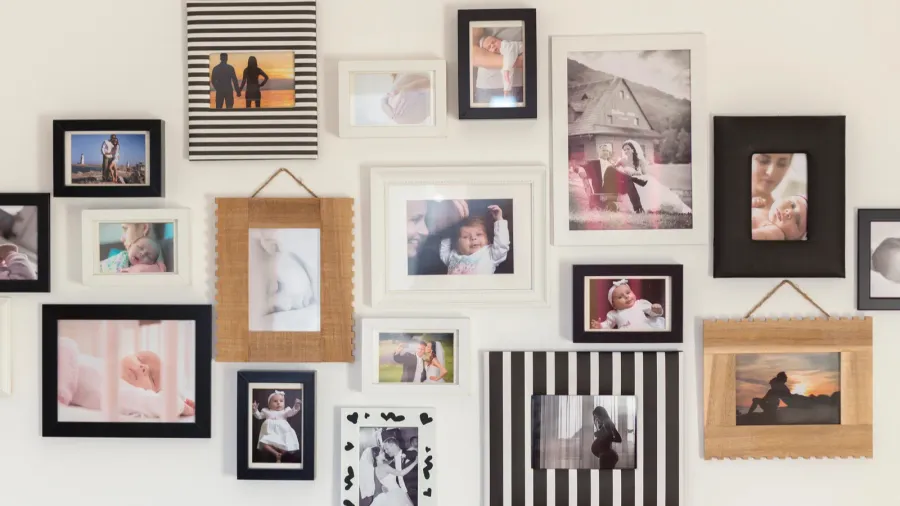 A gallery wall displaying various family photos in mismatched frames.