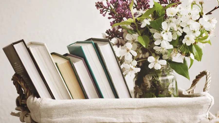 pile of books and spring flowers of a lilac and