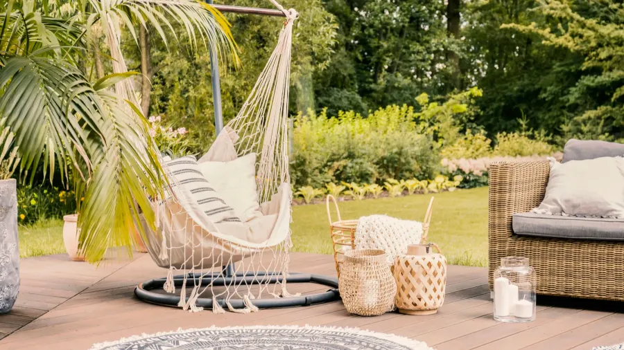 pillows on hammock on terrace with round rug and rattan