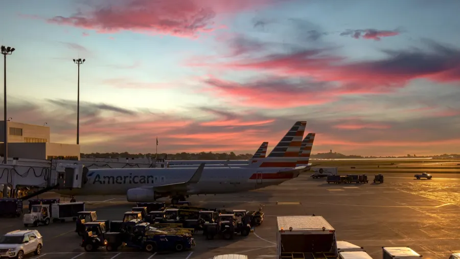 planes departing from boston logan airport at sunset