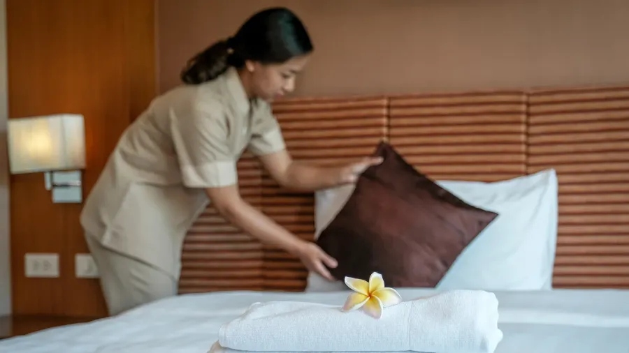 plumeria and towels in front of hotel maid making the