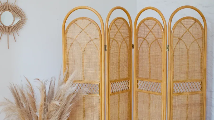 Rattan folding screen room divider in a room.