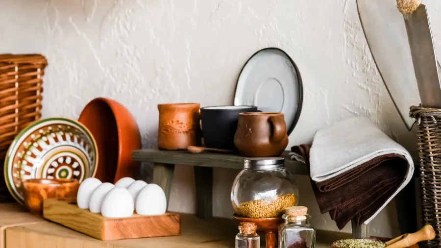 raw eggs near clay bowls and glass bottles in kitchen