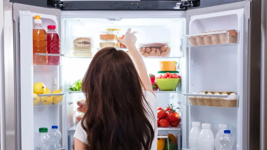 rear view of a young woman taking food to eat