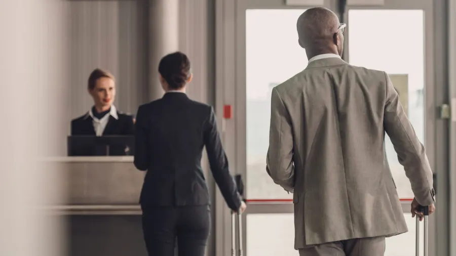 rear view of businesspeople walking to airport check in counter
