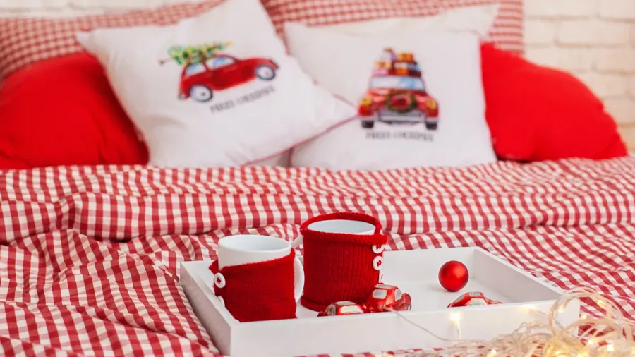 red knitted cups of tea staying on wooden tray with