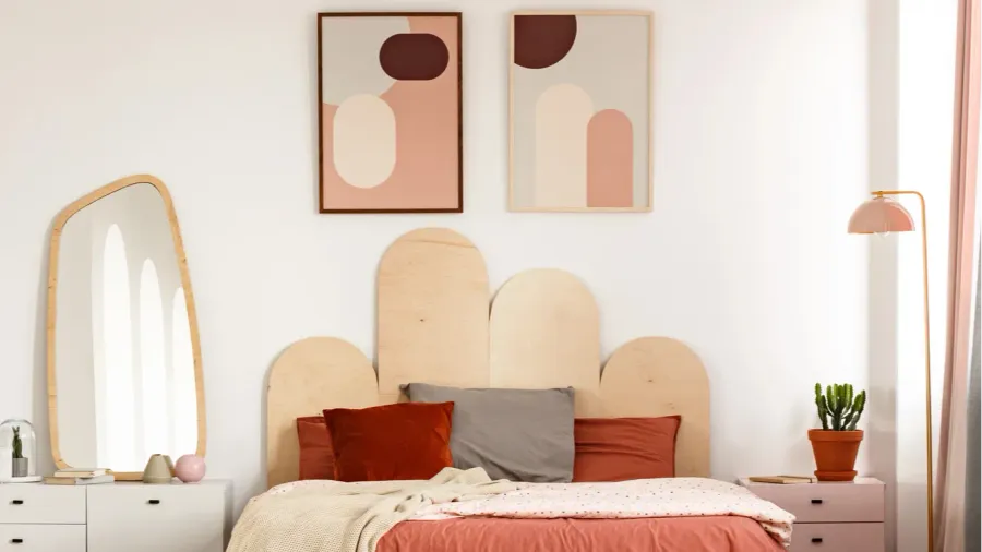red sheets on bed in modern bedroom interior with posters