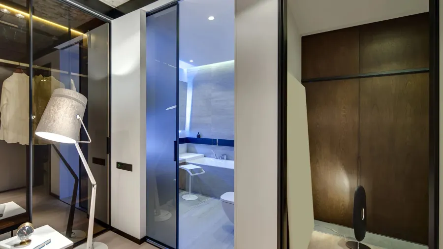 A bedroom interior with a glass pocket door leading to a bathroom.