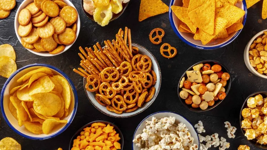A snack station with various snacks in bowls on a table.