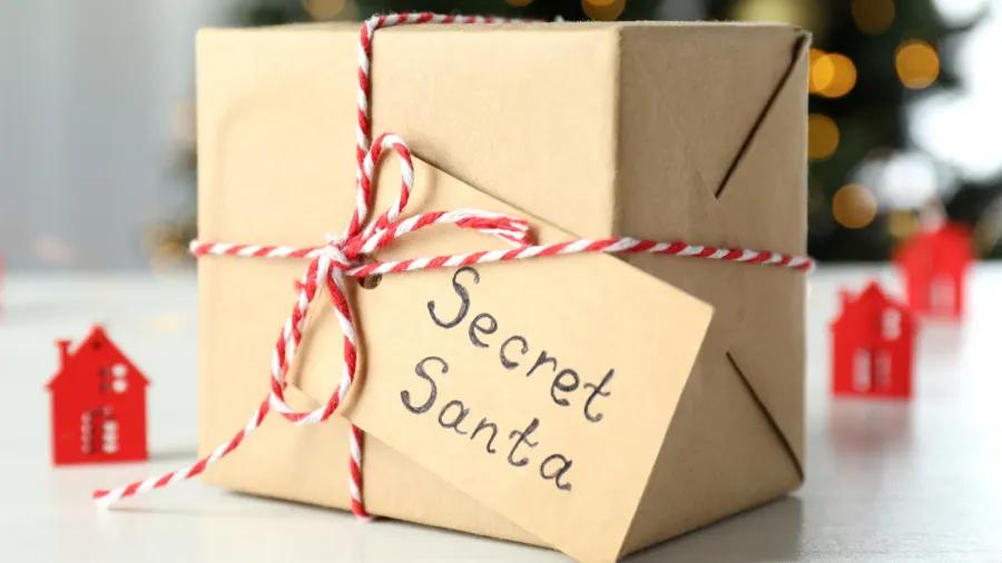 secret santa and christmas composition on white wooden table