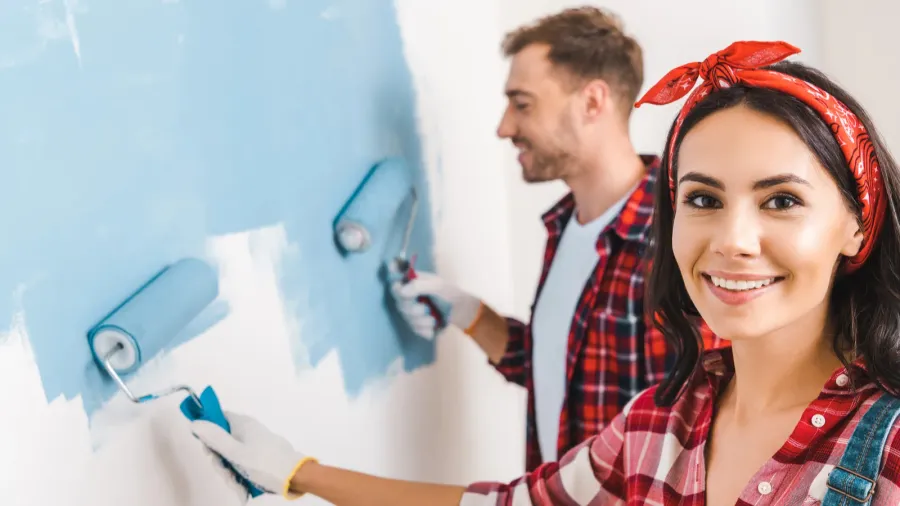 selective focus of attractive woman holding roller near man painting