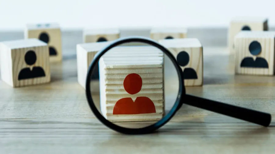 selective focus of magnifying glass near cubes on wooden desk