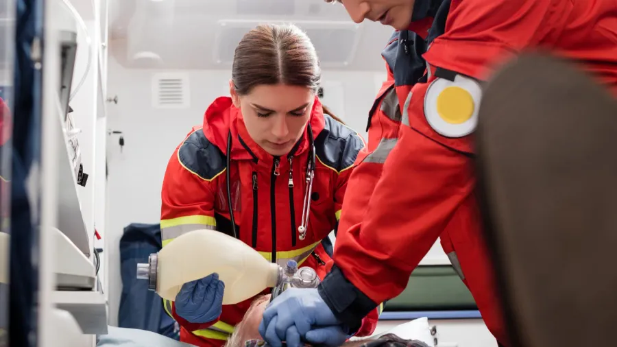 selective focus of paramedics in uniform doing cardiopulmonary resuscitation to