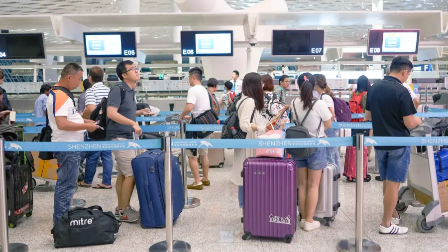 Travelers waiting in line inside of Shenzhen Bao'an International Airport.