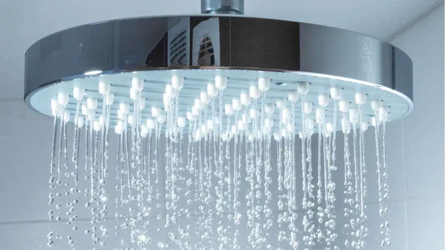 shower head with water stream on grey background